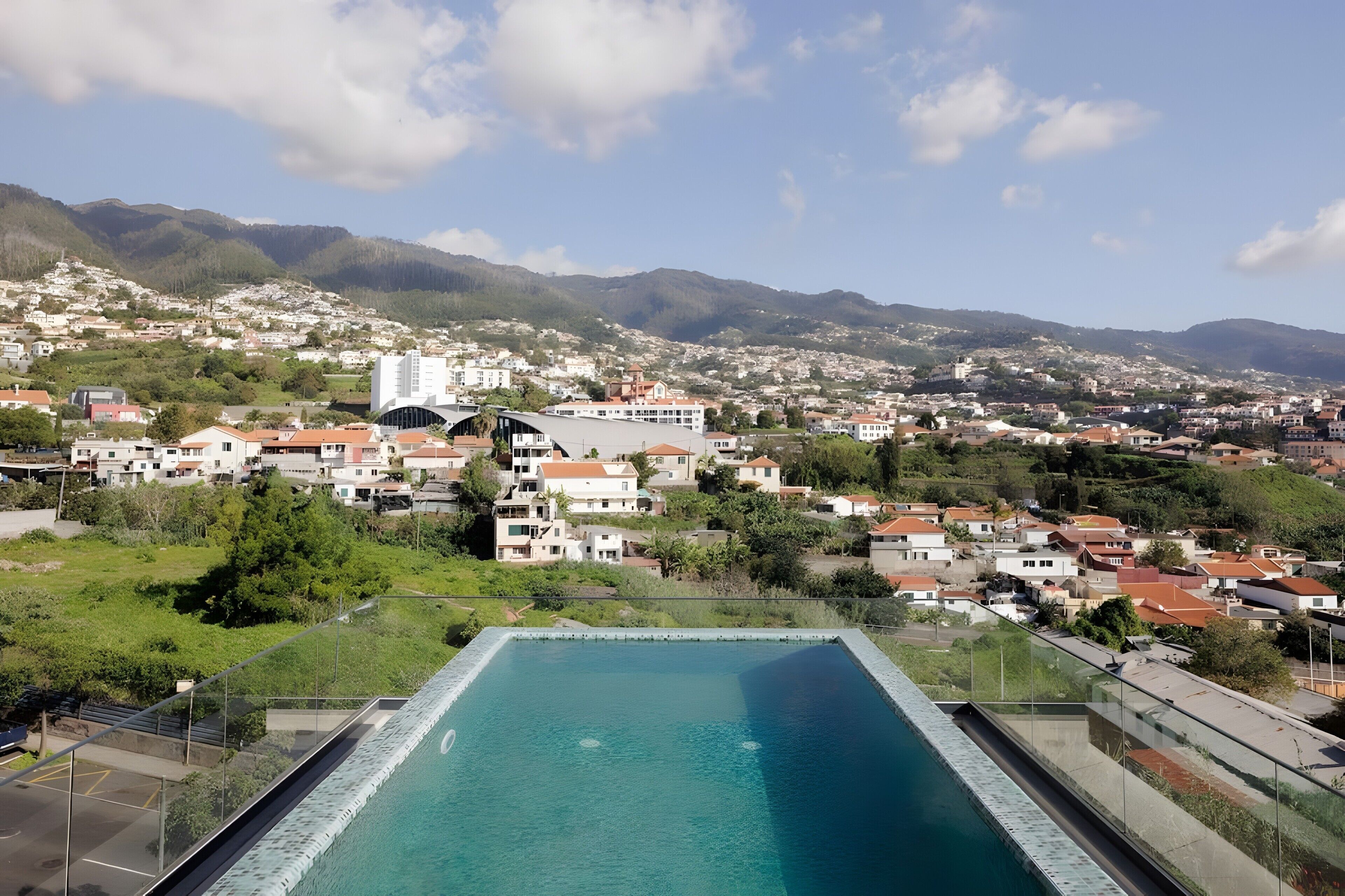 Zona residencial con piscina, casas y montañas al fondo.