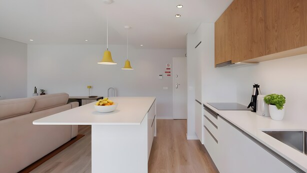 A modern kitchen with white cabinetry, a central island with a bowl of fruit, and a wooden ceiling.