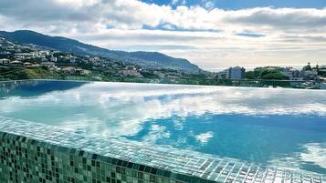 Una piscina amb vores de rajola, cel serena i muntanyes llunyanes.
