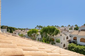 A coastal town with terracotta-tiled roofs, white buildings, and palm trees. - Holiday Home 'Sun, Beach, Pools & Gardens' with Shared Pool, Wi-Fi & Air Conditioning (Gran Alacant)