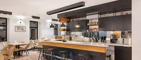 A modern kitchen with a central island, bar stools, and a dining area with chairs.