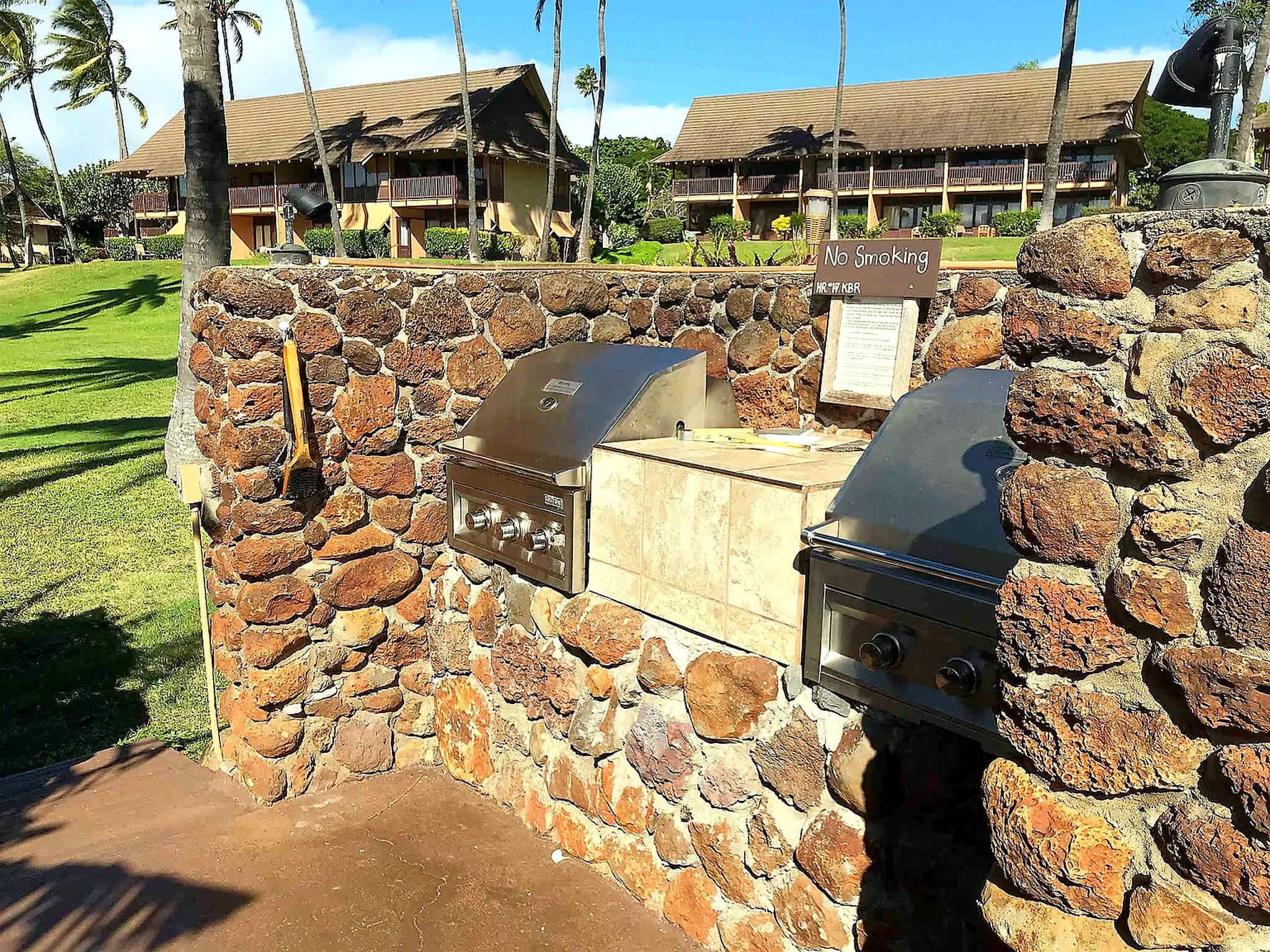 A stone barbecue area with a grill and a sign indicating no smoking.