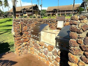 A stone barbecue area with a grill and a sign indicating no smoking.