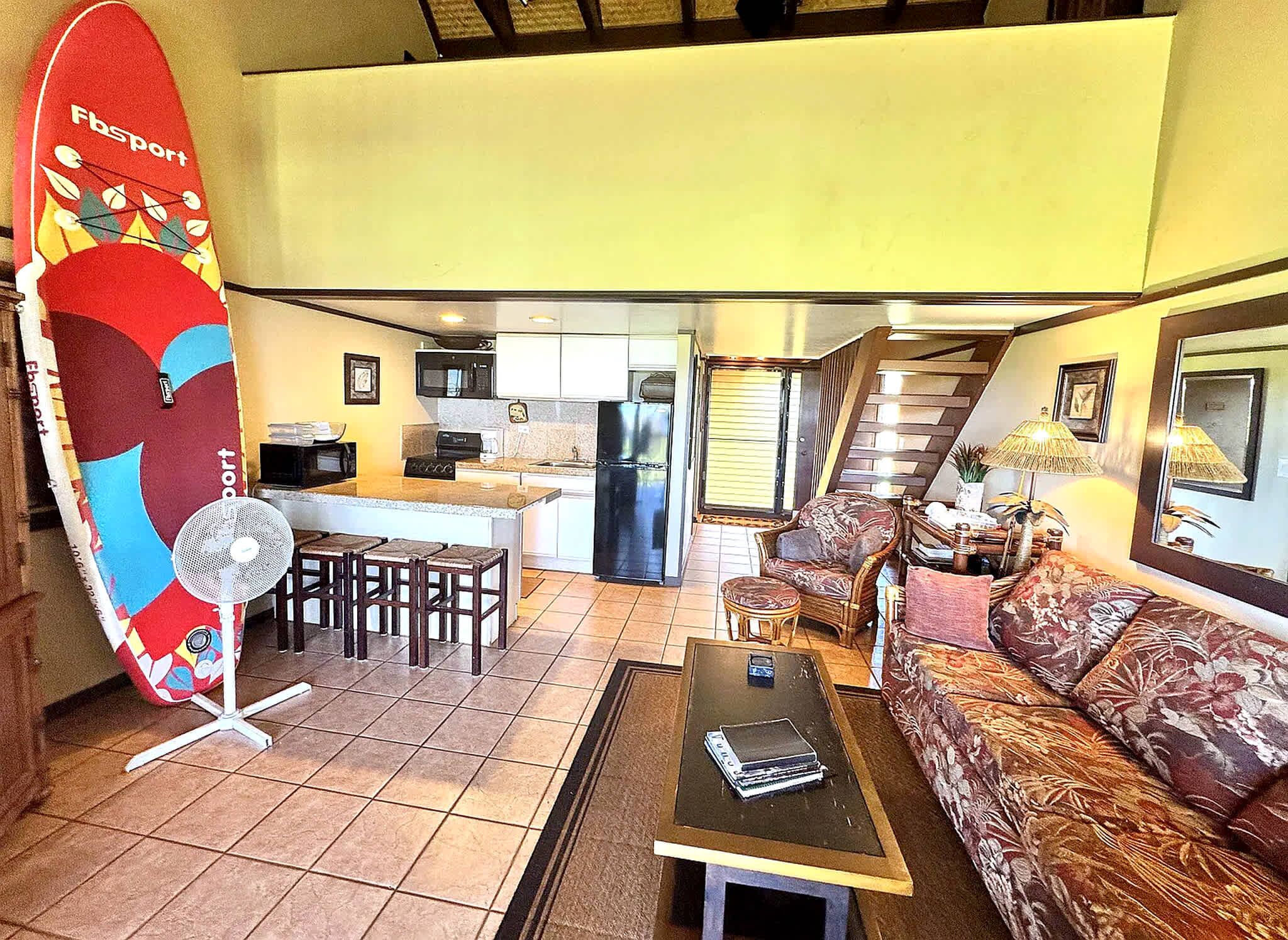 A compact living space with a kitchenette, a dining area, and a seating area with a sofa and chairs.