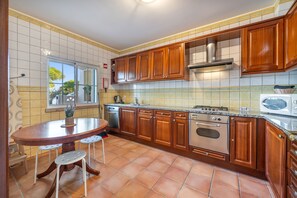 A kitchen with wooden cabinets, a stove, and a sink. - Holiday Home '7 Vales' with Sea View, Wi-Fi and Air Conditioning (Lagoa)