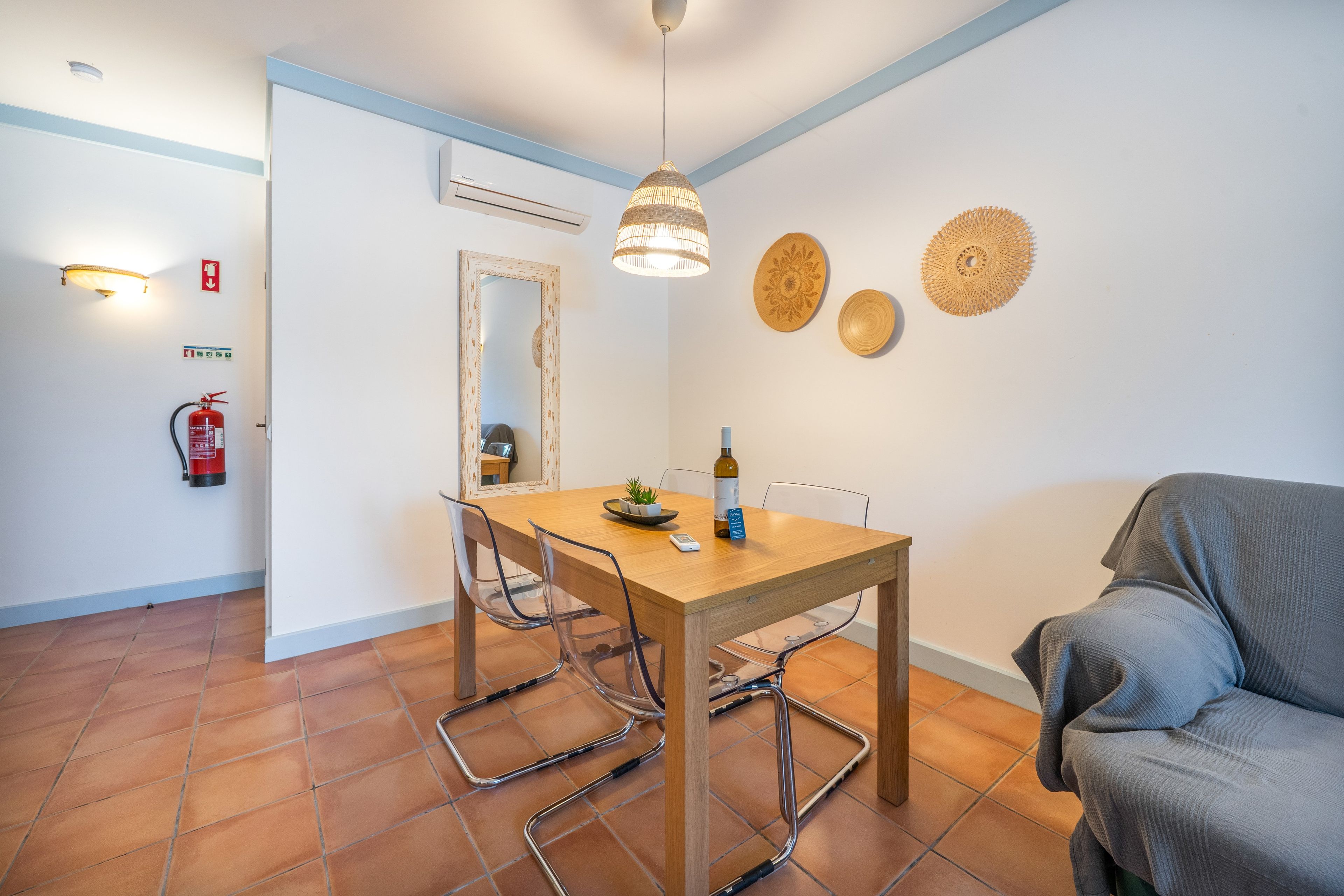 Een eetgedeelte met een houten tafel, stoelen en een hanglamp.