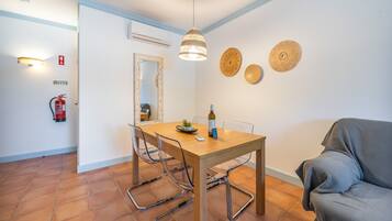 Een eetgedeelte met een houten tafel, stoelen en een hanglamp.
