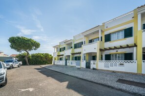 A multi-story building with a paved driveway and parked cars. - Holiday Home '7 Vales' with Sea View, Wi-Fi and Air Conditioning (Lagoa)