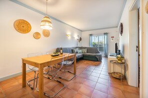 A compact living space with a dining area, sofa, and a small table with chairs. - Holiday Home '7 Vales' with Sea View, Wi-Fi and Air Conditioning (Lagoa)