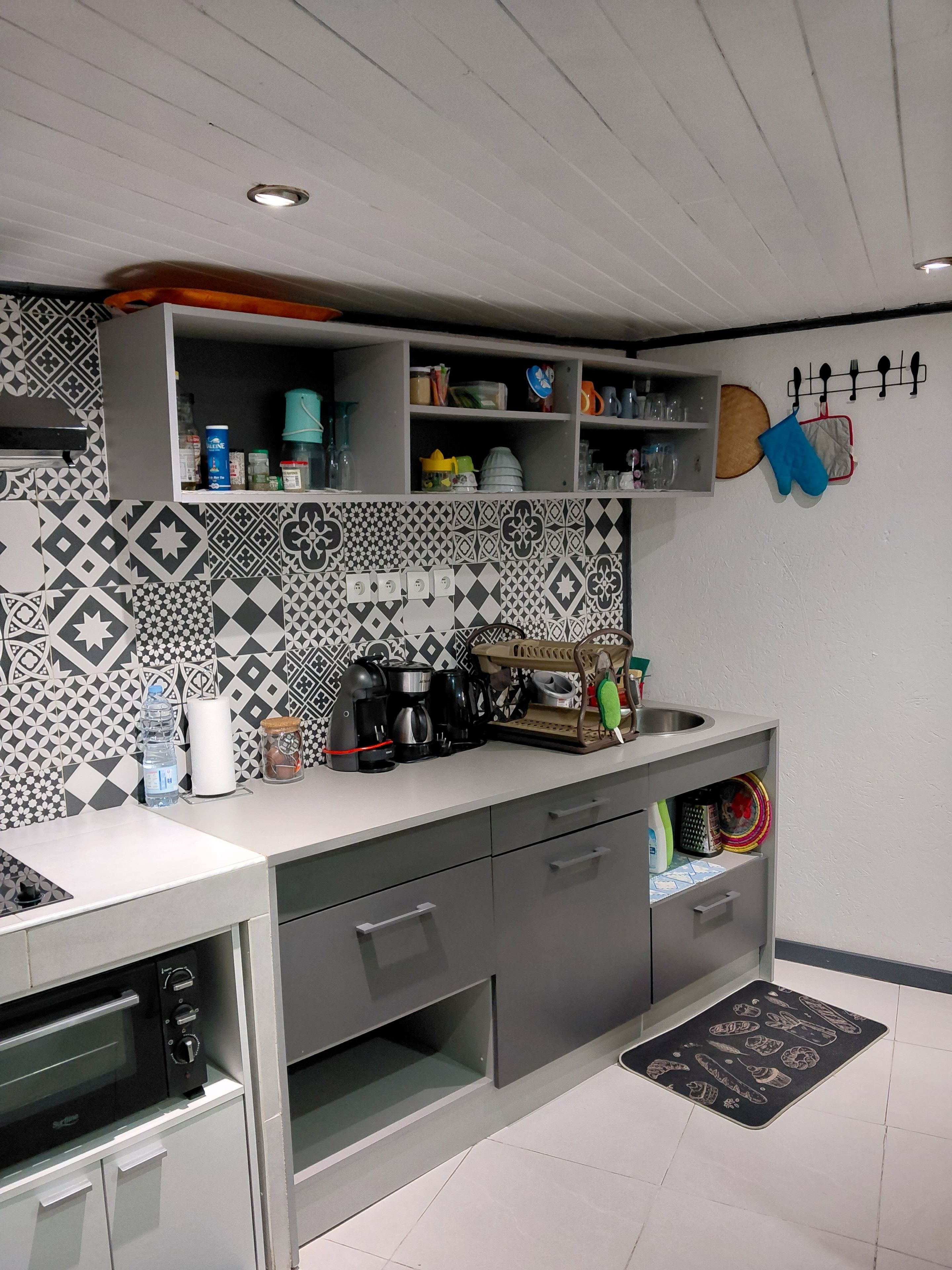 Una cocina moderna con salpicadero estampado, electrodomésticos integrados y una variedad de utensilios y utensilios de cocina.