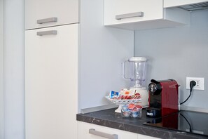 A kitchen with a blender, a coffee maker, and a container with food items on the counter. - ‘Dolomis Margherita 4px’ Apartment with Mountain View, Shared Garden and Wi-Fi (Caderzone Terme)