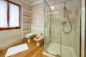 A bathroom with a glass-enclosed shower, a toilet, and a bidet. - Dolomis Apartments Rododendro 6 Guests (Caderzone Terme)