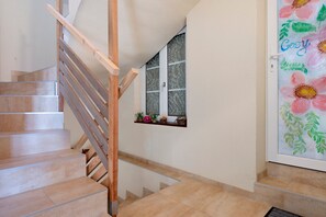 Una escalera con barandillas de madera y baldosas color beige.