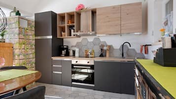Une cuisine moderne équipée d’un four encastré, d’une machine à café et d’un évier.