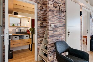 A modern bathroom with a wooden vanity, a mirror, and a towel rack.