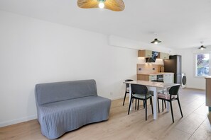 Un espace de vie compact comprenant une kitchenette, un coin repas et un canapé.
