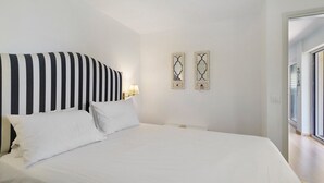 Ein Hotelzimmer mit einem großen Bett, zwei Nachttischlampen und zwei dekorativen Wandspiegeln.