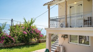 Ein zweistöckiges Gebäude mit Balkon, Treppe und Meerblick.