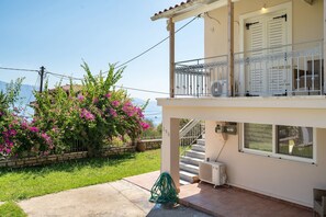 Ein zweistöckiges Gebäude mit Balkon, Treppe und Meerblick.