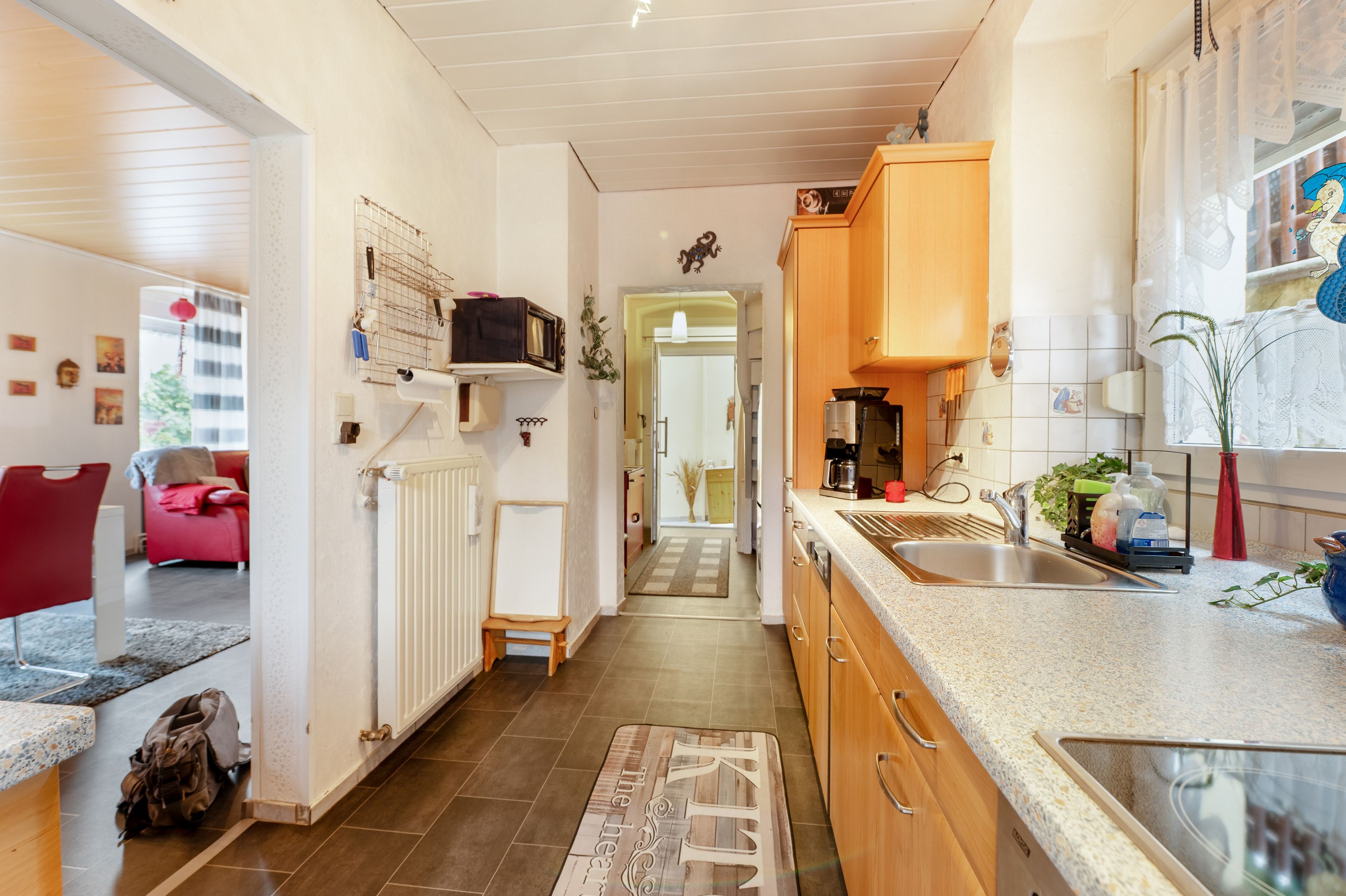 Une cuisine moderne dotée d’un îlot central, de meubles en bois et donnant sur la salle à manger.