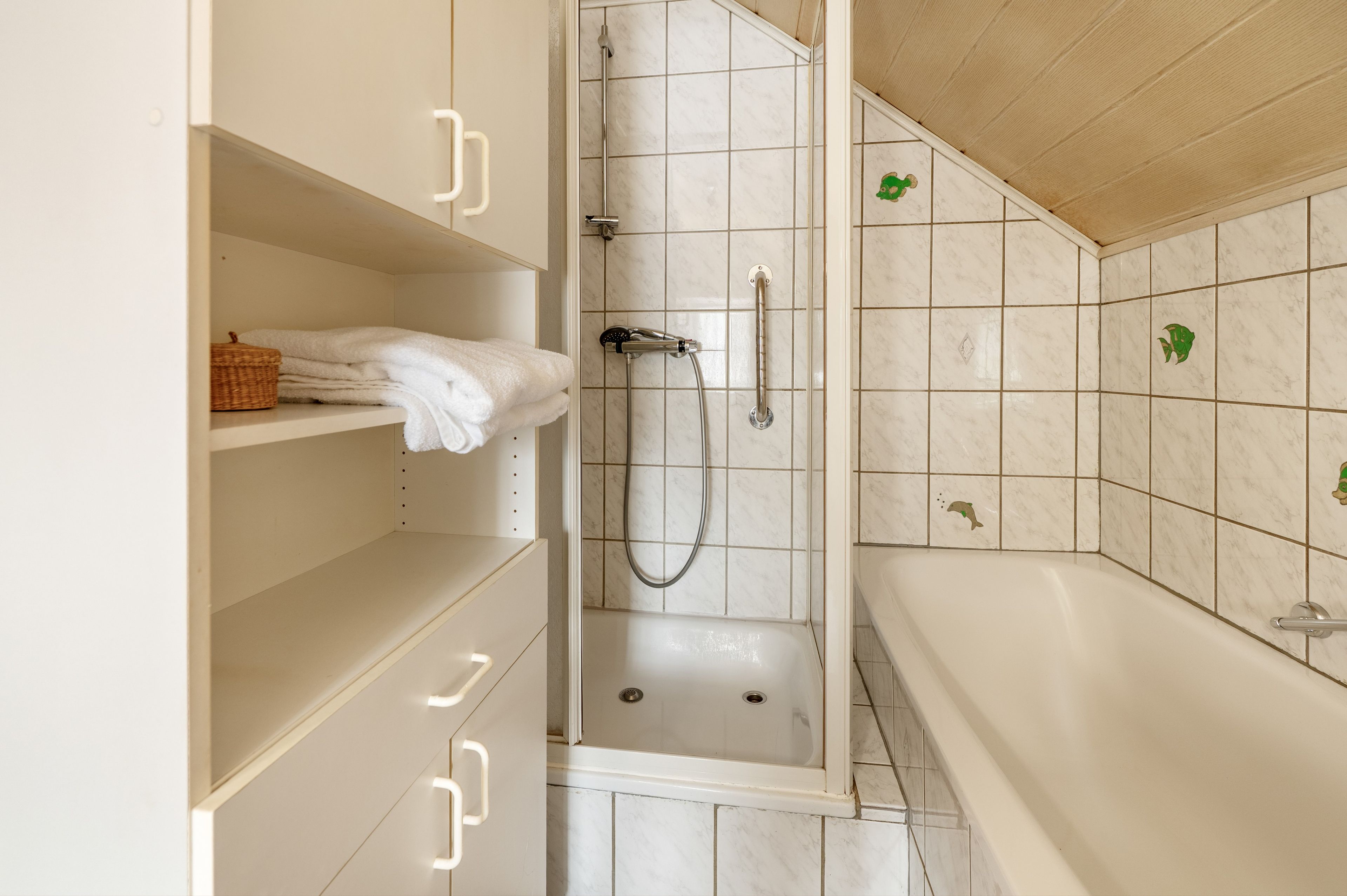 Ein Badezimmer mit einer begehbaren Dusche, einer Badewanne und einem Ablagebereich für Handtücher.