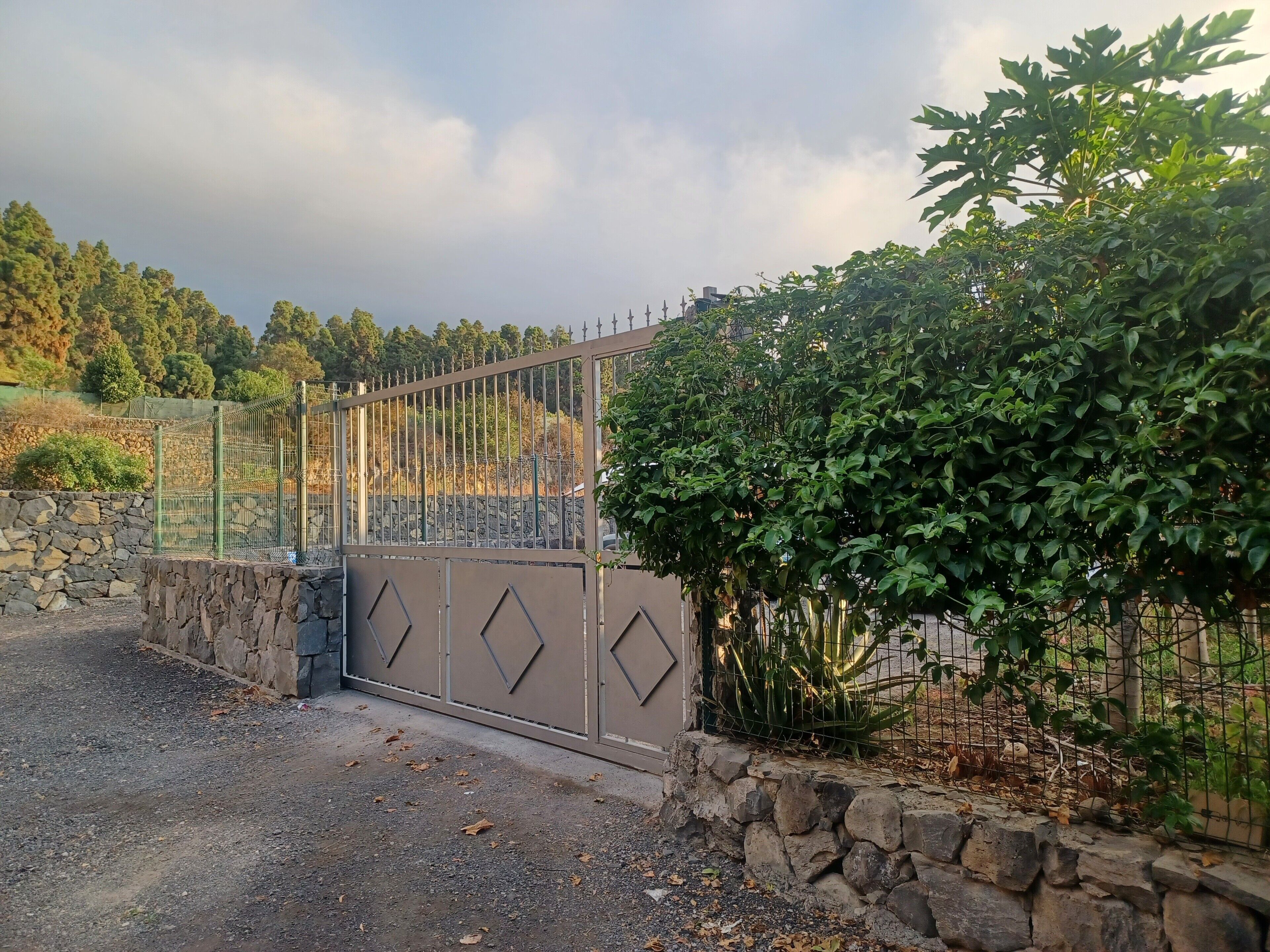 Una entrada tancada amb mur de pedra i tanca metàl·lica.