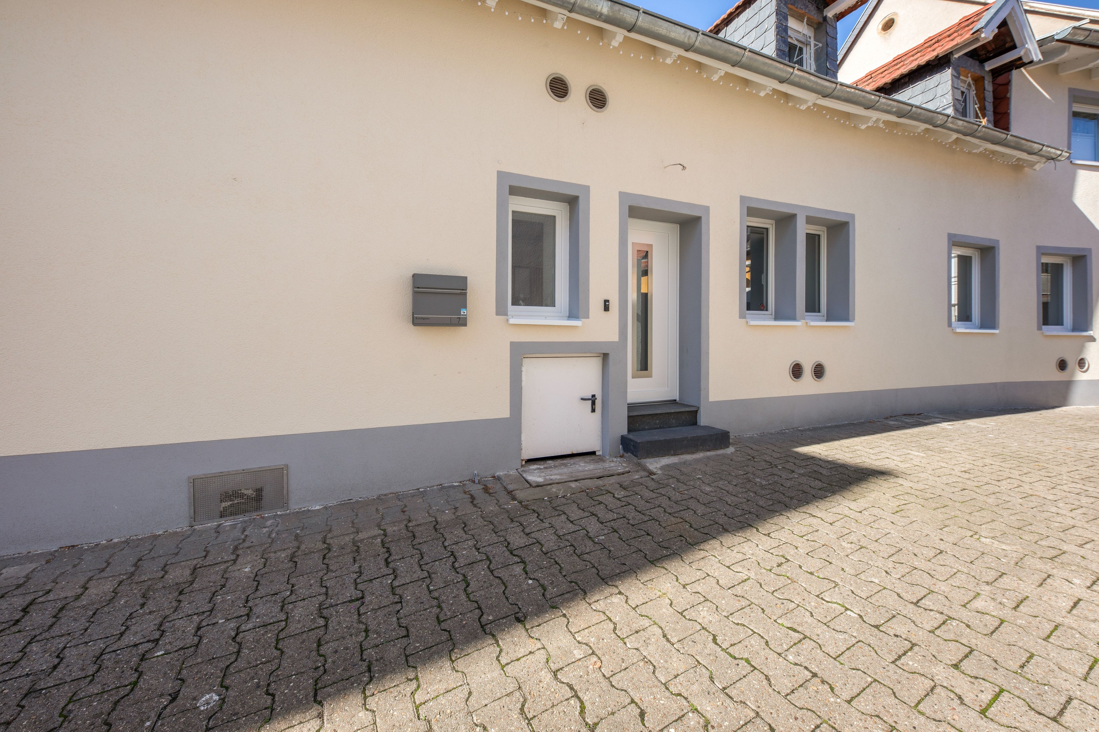 Ein Gebäude mit flacher Fassade, einer Tür und zwei Fenstern.