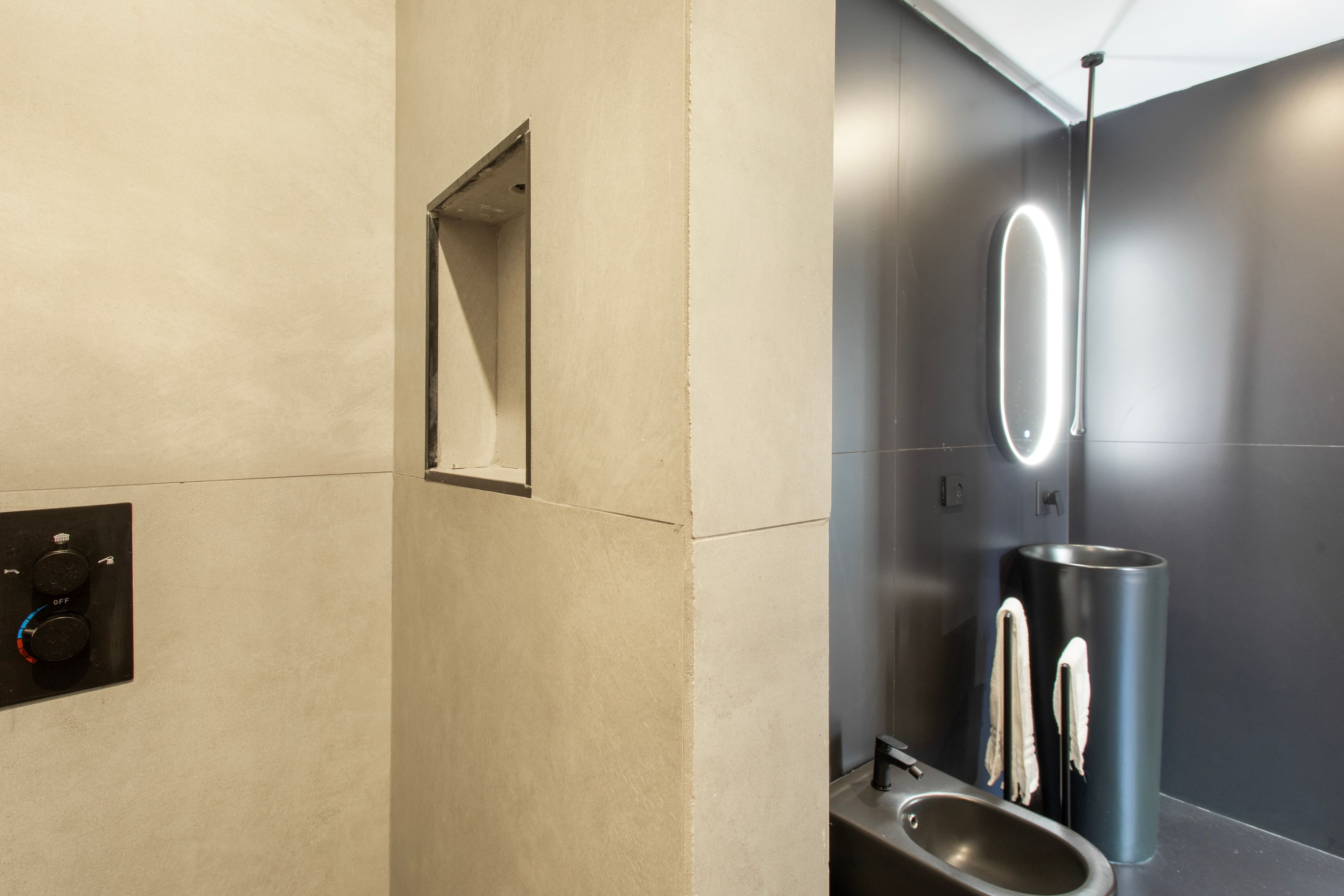 A modern bathroom with a mirror, a sink, and a towel rack.