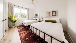 A bedroom with two single beds, a large window, a ceiling fan, and a view of the outdoors. - Nashville Rooftop Home with Hot Tub & Skyline Views (Nashville)