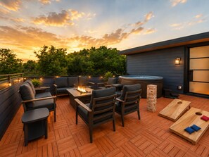 An outdoor patio with a fire pit, seating area, and a hot tub. - Nashville Rooftop Home with Hot Tub & Skyline Views (Nashville)
