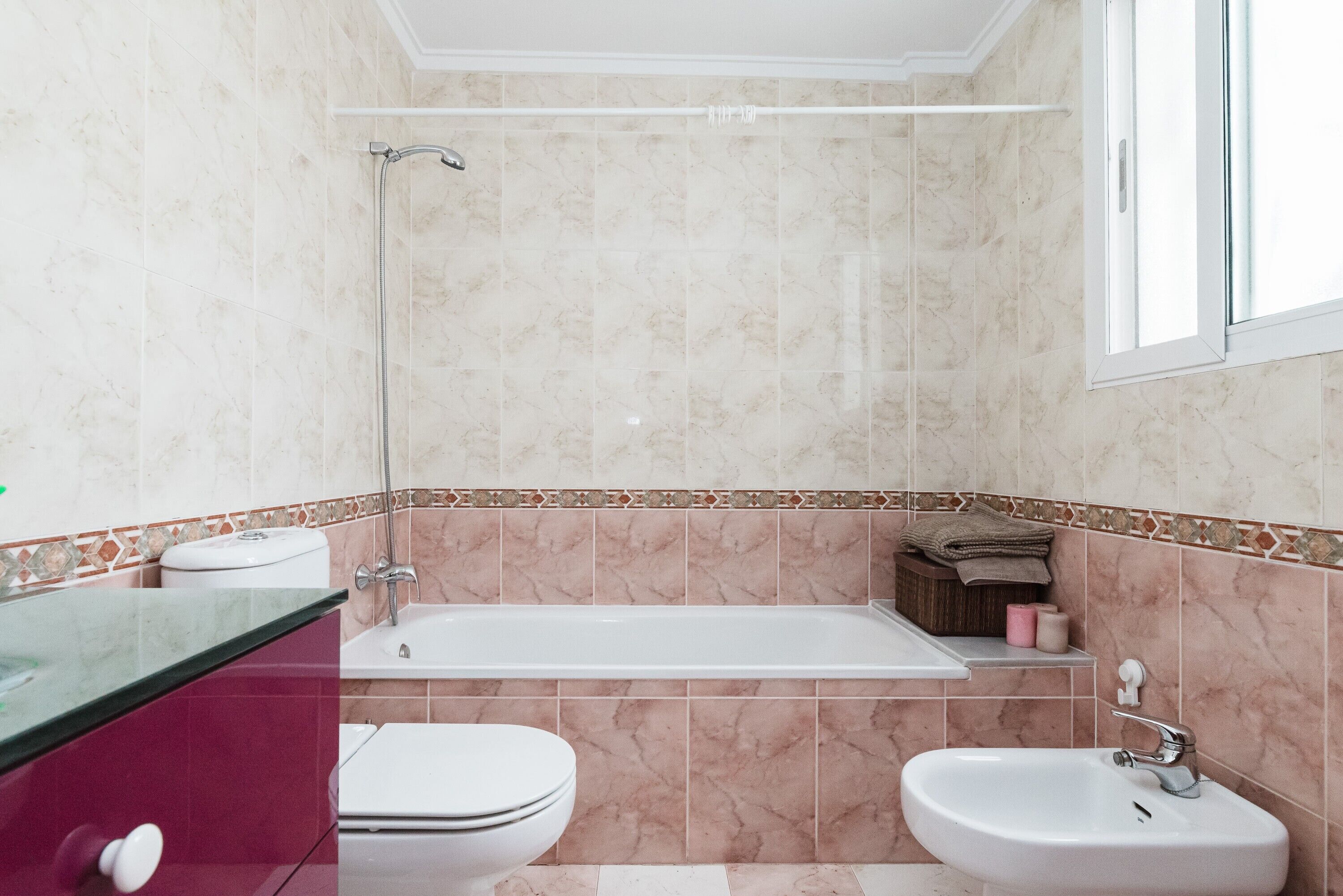 Et badeværelse med badekar, håndvask og toilet.