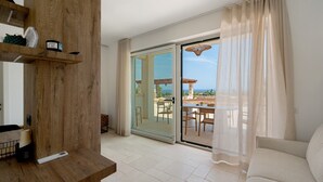 A modern living room with a wooden accent wall, a sliding glass door leading to an outdoor patio, and a white sofa.