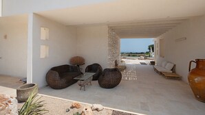 An outdoor seating area with wicker furniture and a view of the beach.