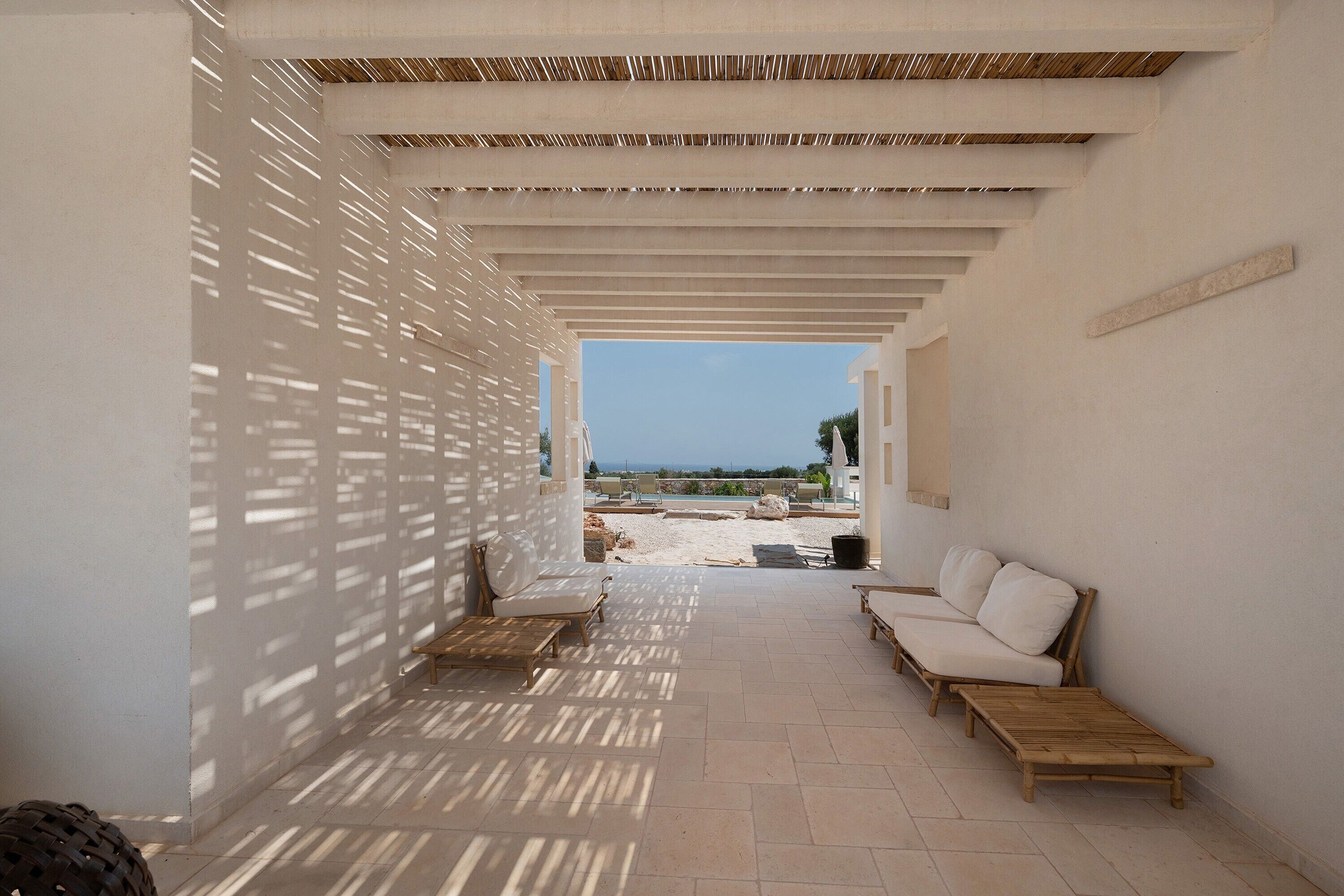 A covered outdoor seating area with a view of the beach.