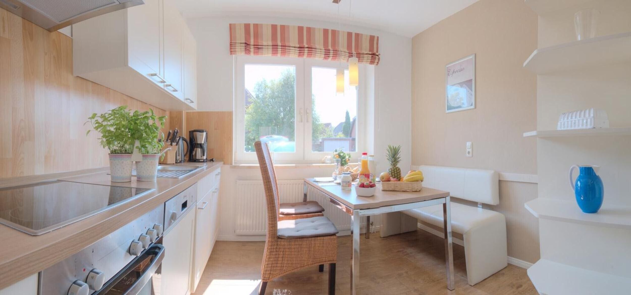 Une cuisine moderne avec un coin repas, une fenêtre avec des rideaux et un banc blanc.