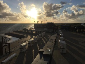 A coastal promenade with seating areas, a pier, and a view of the sea. - Apartment Amrumbank Terrace with Private Garden, Terrace, and Wi-Fi (Büsum)