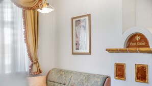 A room with a sofa, a framed picture on the wall, and a sign with the name 'Gratt Xhissli'. - Apartment “Grattschlössl 1” with Mountain View, Balcony, and Wi-Fi (Sankt Johann)