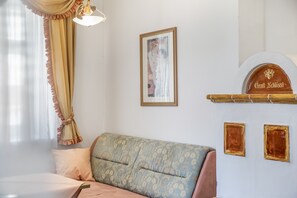 A room with a sofa, a framed picture on the wall, and a sign with the name 'Gratt Xhissli'. - Apartment “Grattschlössl 1” with Mountain View, Balcony, and Wi-Fi (Sankt Johann)