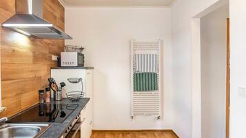 A modern kitchen with a stainless steel sink, wooden cabinets, and a built-in microwave.