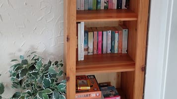 Une bibliothèque en bois avec plusieurs étagères, un certificat encadré et une plante en pot.