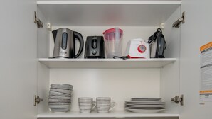 Un armario de cocina con electrodomésticos y vajilla.