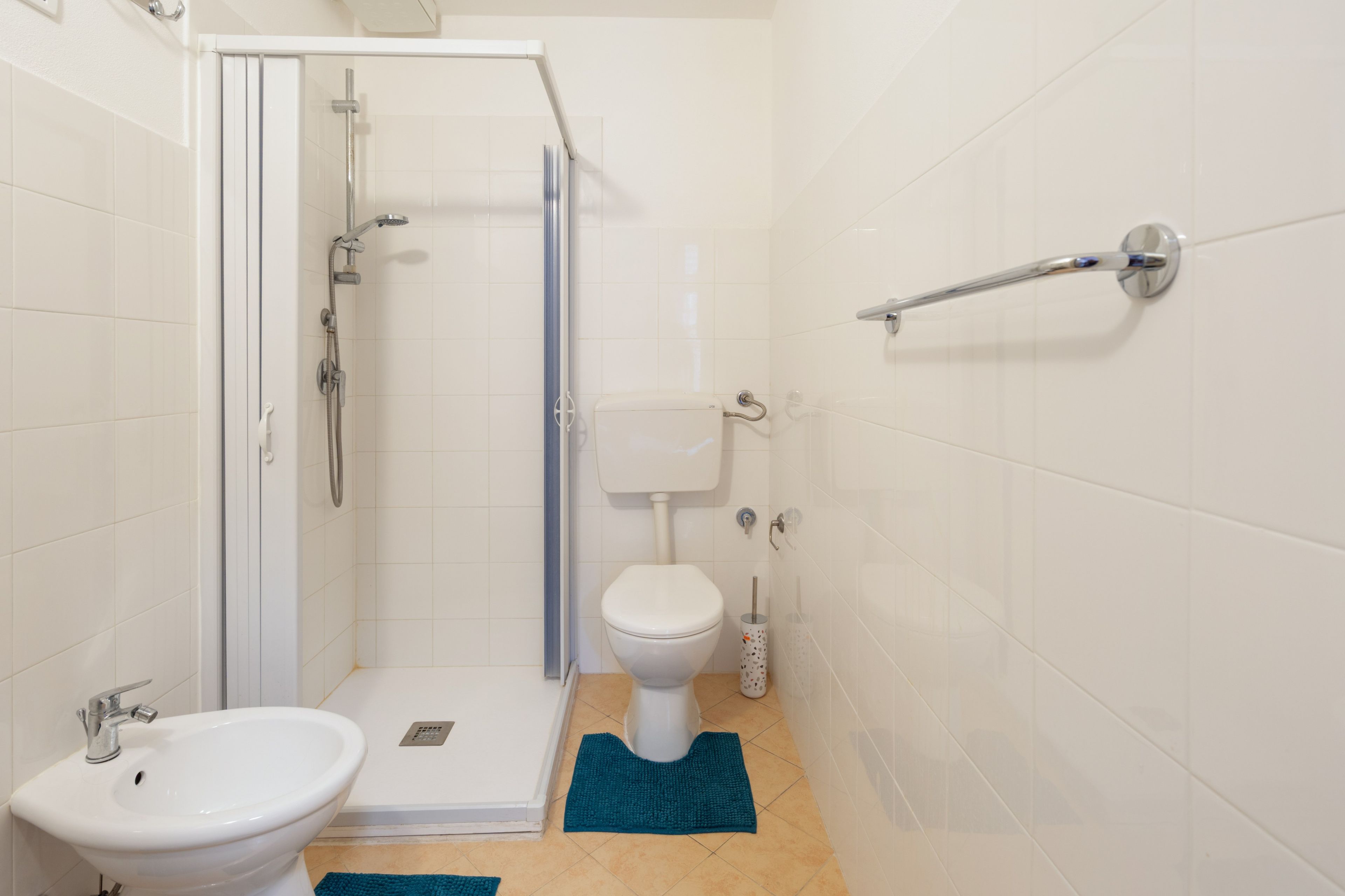 Une salle de bain équipée d’une douche, de toilettes, d’un bidet et d’un lavabo.