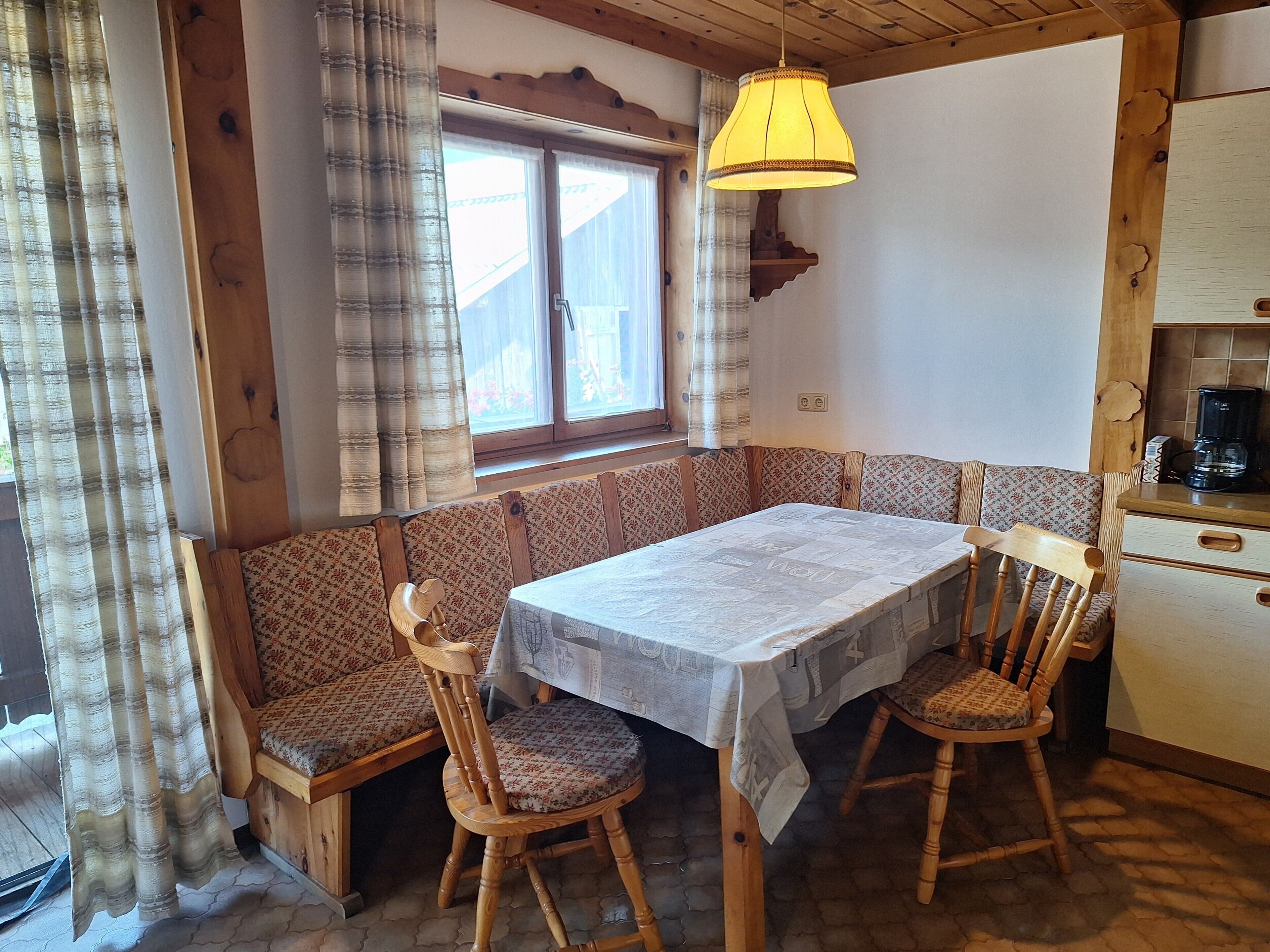 A cozy kitchen with a wooden bench, a table, and chairs.