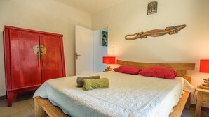 Ein Schlafzimmer mit einem Bett, einem Holzschrank und einer Wandlampe.