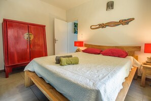 Ein Schlafzimmer mit einem Bett, einem Holzschrank und einer Wandlampe.