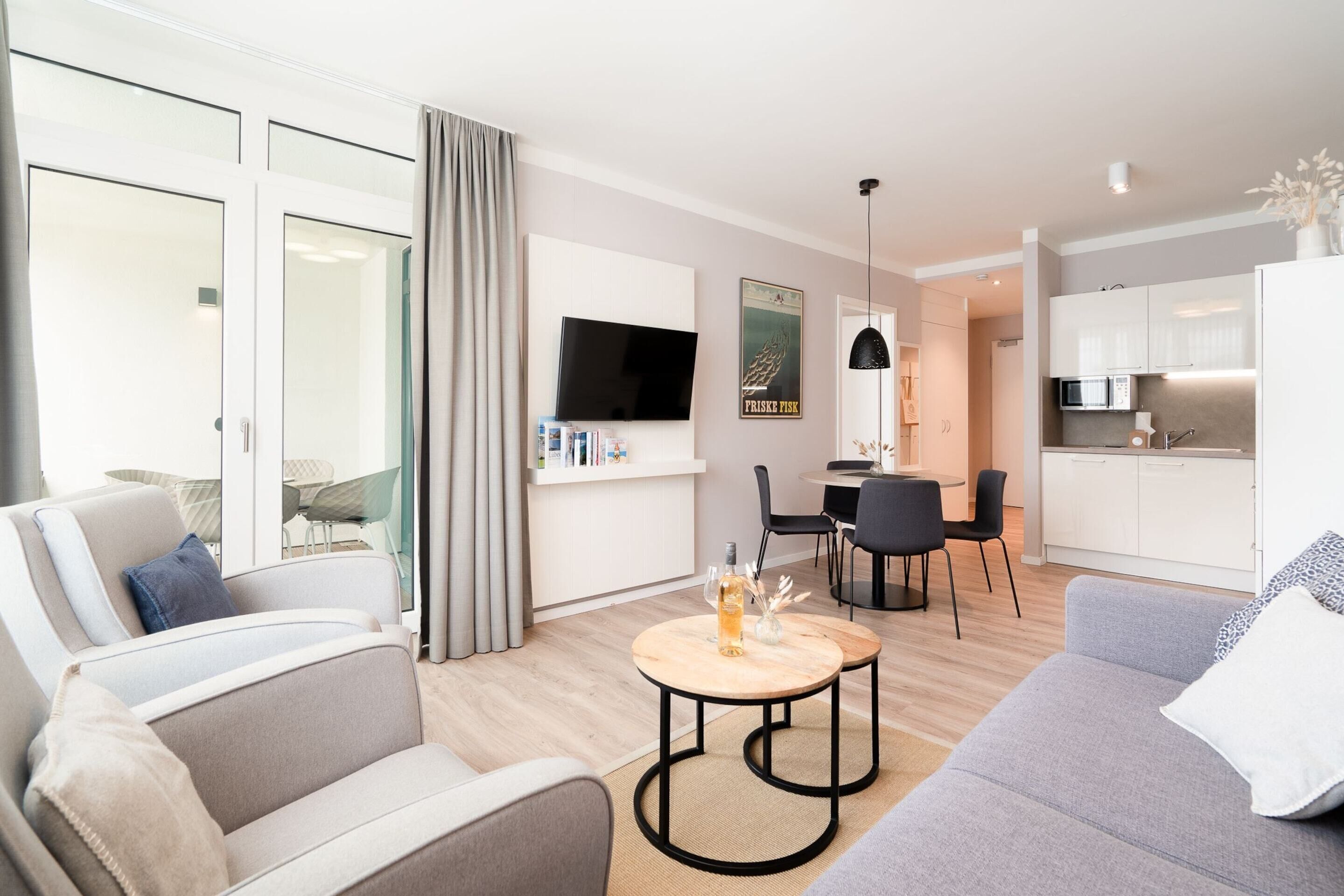 Una sala de estar moderna con un sofá, una mesa de centro y un comedor con sillas.