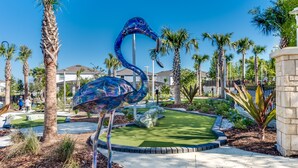 A landscaped area with a large blue sculpture of a bird, palm trees, and a building in the background. - Sleeps 14 *Private Pool *Arcade Games *BBQ Grill (Davenport)