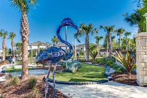 A landscaped area with a large blue sculpture of a bird, palm trees, and a building in the background. - Sleeps 14 *Private Pool *Arcade Games *BBQ Grill (Davenport)