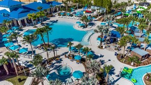 Ein Resort mit mehreren Swimmingpools, Liegestühlen und Palmen.