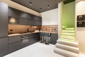 A modern kitchen with dark cabinetry, a built-in oven, and a wooden countertop. - Bed and Breakfast 'Vicolo Del Fortino - Suite 101' with Balcony, Wi-Fi and Air Conditioning (Catania)